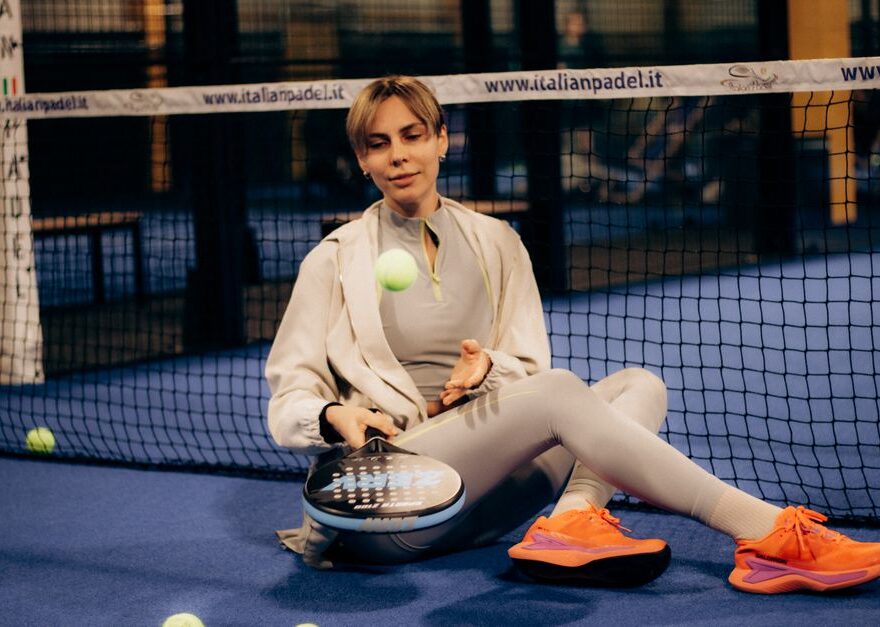 Een sportieve vrouw in warme leggings terwijl ze padel speelt in de winter, genietend van haar spel in koude omstandigheden.